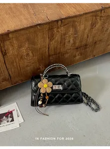 Detailansicht der schwarzen gesteppten Damentasche mit Kette und schönem Blumenanhänger.