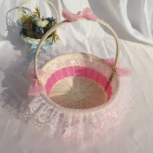 Vue détaillée du panier de mariage tissé à la main avec dentelle et nœuds roses pour enfants.