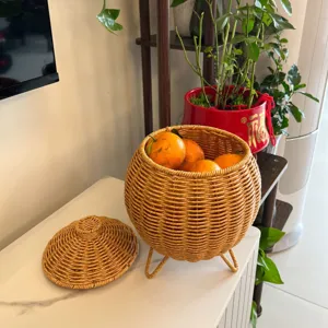 Handwoven imitation rattan lidded storage basket with tripod stand for desktop organization.