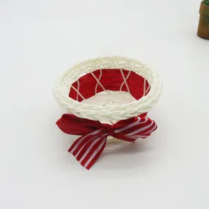 Handgemaakte witte rotan opbergmand met rode strik, ideaal voor snoep en kleine spulletjes.