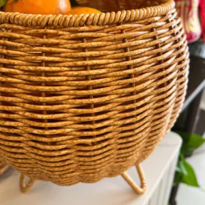 Close-up of hand-woven imitation rattan storage basket texture and tripod base details.