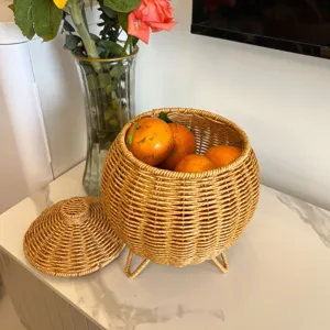 Hand-woven rattan storage basket with lid and tripod legs, perfect for desktop organization.