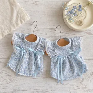 Vue détaillée de la jolie robe florale bleue pour animaux de compagnie avec de beaux nœuds.