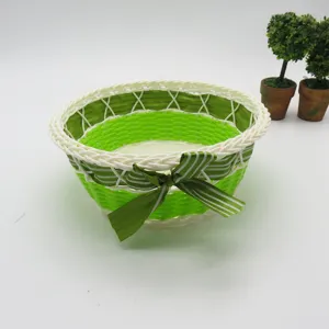 Panier de rangement tressé en plastique avec nœud vert pour bureau et organisation.