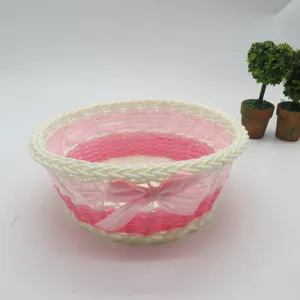 Panier de rangement de bureau en plastique détail, organisateur tressé rose et blanc avec nœud.