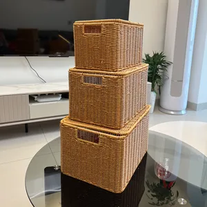 Vue détaillée de boîtes de rangement imitation rotin marron empilées avec couvercle.