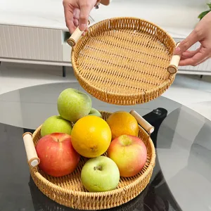 Bandeja redonda de ratán tejido con asas de madera, ideal para almacenar fruta y pan fresco.