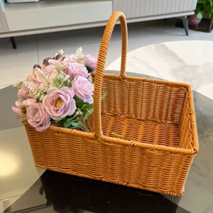 Close-up detail of the brown woven storage basket filled with pink artificial roses in a room.