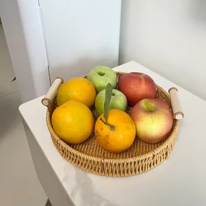 Bandeja redonda hecha a mano de imitación ratán con asas de madera para frutas y pan.