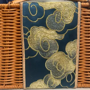 Detailed close-up view showing the exquisite golden embroidered cloud pattern on the basket.