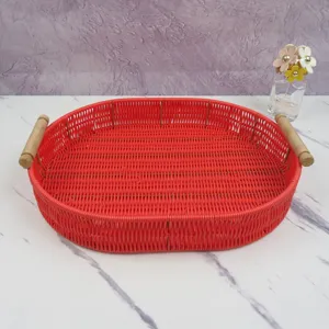 Red woven storage tray with wooden handles, oval fruit and bread basket for home desktop decor.