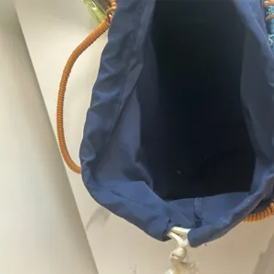 Detailed view of the inner fabric lining and drawstring closure of a woven rattan basket.