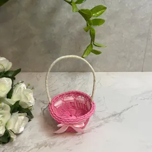 Mini pink woven flower basket with white handle and bowknot, perfect for home decor and storage.