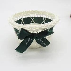 Handmade white woven storage basket with green ribbon for desktop sundries and snacks.