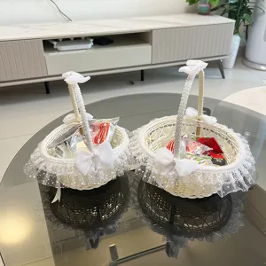 Dettaglio del cestino in rattan bianco da damigella con fiocco in pizzo e bordo in tulle.