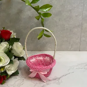 Mini woven flower basket with handle, pink decorative storage basket for desktop and home decor.