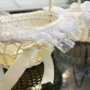 Primo piano dettagliato del cesto da sposa bianco in vimini con pizzo raffinato e nastro.
