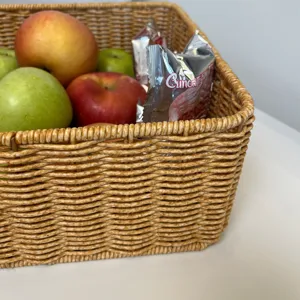 Détail de panier de rangement rectangulaire en rotin synthétique pour organisation maison.
