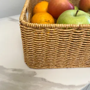 Panier de rangement imitation rotin fait main en détail, avec doubles poignées pratiques.