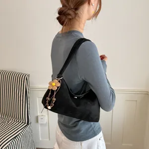 Schwarze Wildleder Umhängetasche für Damen, schicke Hobo Tasche mit Blumenanhänger.