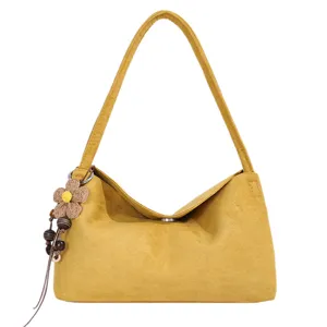 Stylish yellow suede shoulder bag for women, niche design underarm handbag with flower charm.