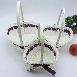 Paniers de fleurs tressés en forme de cœur blanc avec des rubans violets pour mariages.