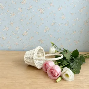 Vue détaillée d'un mini panier en osier blanc avec des fleurs, accessoire photo rustique.