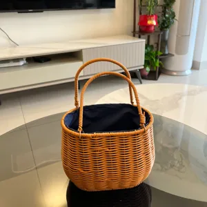 Detailansicht eines handgeflochtenen Rattankorbs mit blauem Futter und doppelten Griffen.
