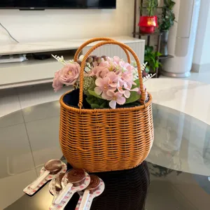 Handgeflochtener Rattanimitat-Aufbewahrungskorb mit Futter und rosa Kunstblumen für Dekoration.