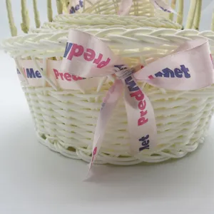 Detailed shot of woven storage basket with pink ribbon bow, handmade design for home organization.