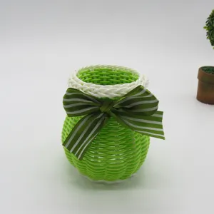 Gedetailleerd overzicht van de groen-witte geweven plastic opbergmand met gestreepte strik.