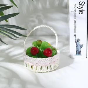 Dettaglio di un cestino di frutta intrecciato rustico con bordo in pizzo rosa e frutta finta.