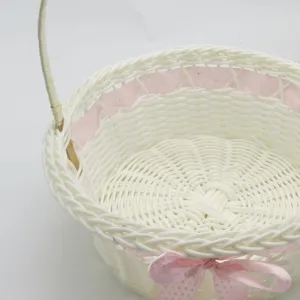 White woven flower basket detail showing the delicate rattan texture and pink bow decoration.