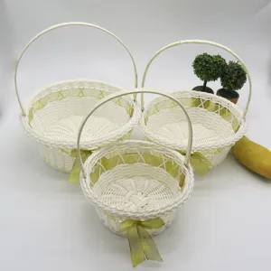 Paniers de fleurs tressés blancs avec nœuds dorés, parfaits pour demoiselles d'honneur.