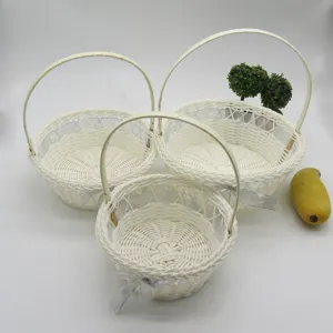 Paniers de fleurs tressés blancs faits à la main avec des rubans argentés pour mariage.