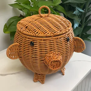 Close-up view of the cute animal-shaped woven storage basket on table with green plant backdrop.