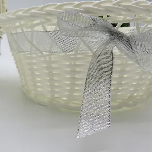 Détail panier bouquetière tressé blanc, nœud ruban pailleté argent, panier mariage.