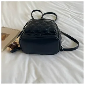 Gros plan sur le mini sac à dos matelassé noir avec une poche zippée pratique.