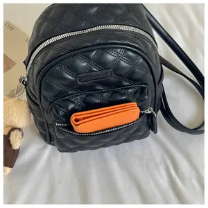 Mini sac à dos matelassé noir avec zips argentés, poche avant et charmant pendentif ourson.