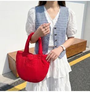 Detailaufnahme der stilvollen roten gesteppten Cloud Tote Tasche mit weicher Textur und Design.