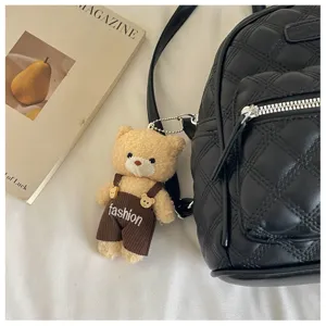 Vue détaillée du sac à dos matelassé noir avec charmant pendentif ours et poche zippée.