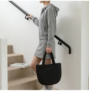 Detailansicht der minimalistischen schwarzen Puffer-Tragetasche, lässige Cloud-Handtasche.