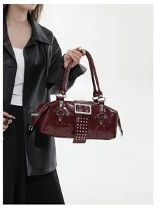 Bordeaux rode laklederen handtas met metalen gespen en klinknagels, stijlvolle tas.