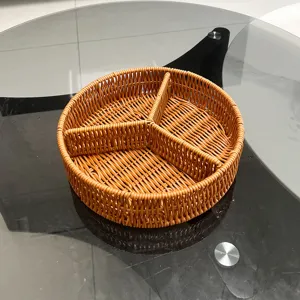 Cesto portaoggetti rotondo in rattan intrecciato a scomparti per organizzare frutta e verdura.