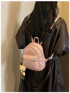 Mini sac à dos matelassé rose pour femme, sac d'école élégant en cuir avec charmant pendentif.