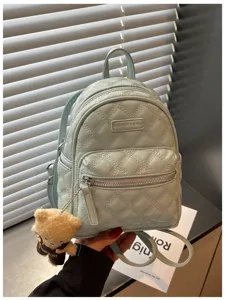 Sac à dos mini matelassé bleu clair élégant avec joli pendentif ours pour usage quotidien.