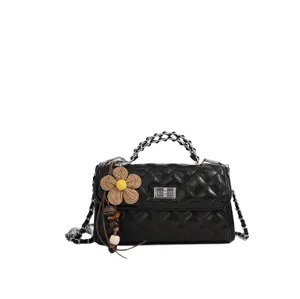 Schwarze gesteppte Damen Umhängetasche mit Metallkette und schönem Strohblumenanhänger.