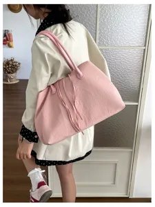 Borsa a tracolla rosa casual indossata su modello, grande capacità e stile quotidiano semplice.