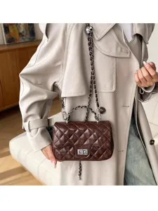 Dettaglio borsa a tracolla trapuntata marrone con catena, chiusura vintage e pelle PU.