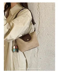 Close-up view of a Korean style vintage suede shoulder bag with braided strap and colorful beads.